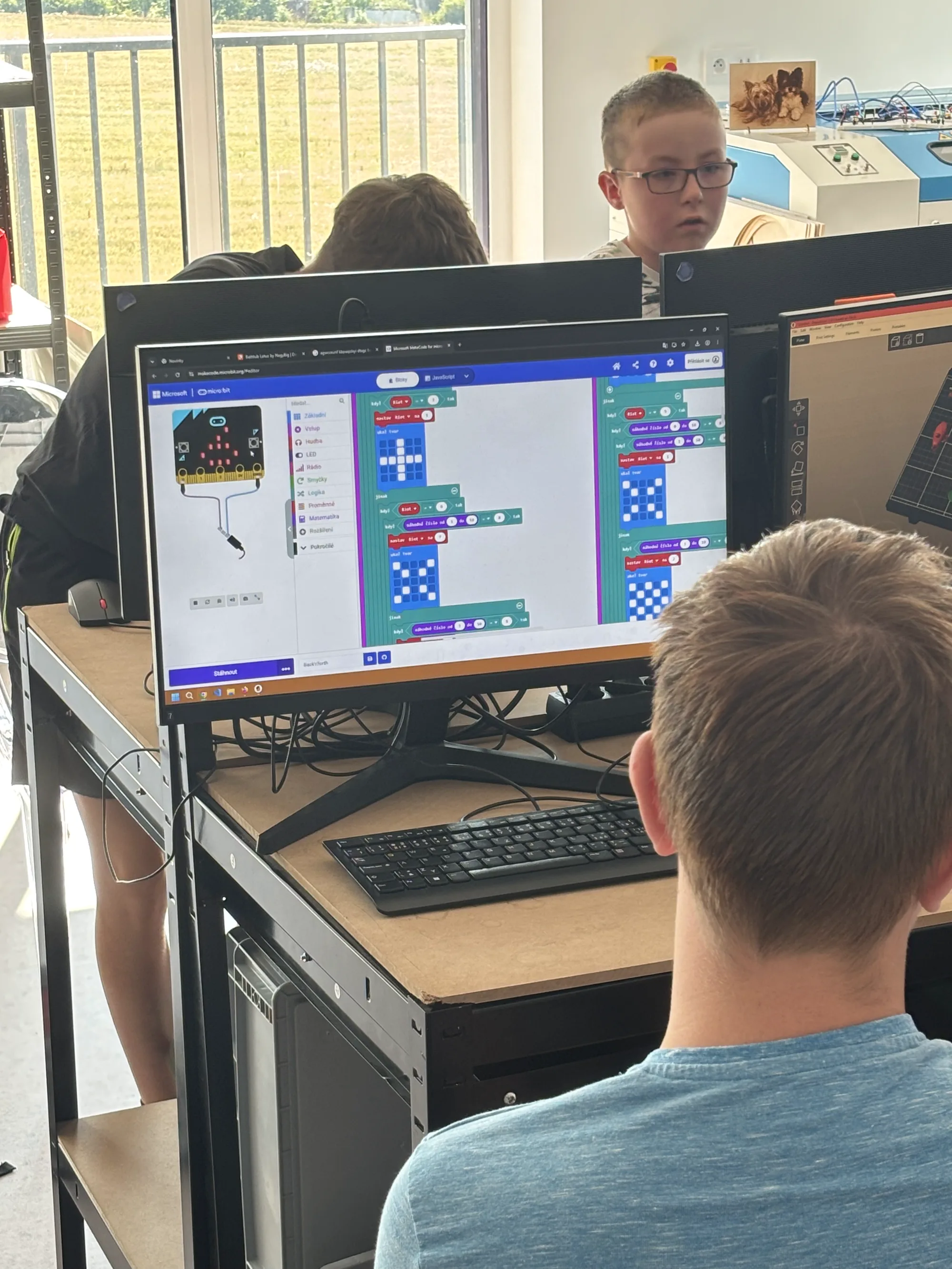 Chlapec skládá program pro micro:bit z barevných bloků